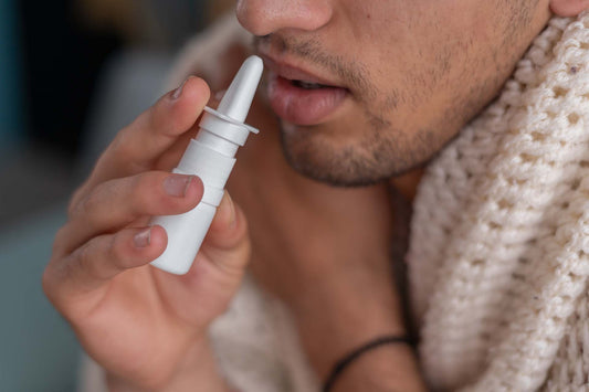 A man demonstrating how to use nasal spray properly