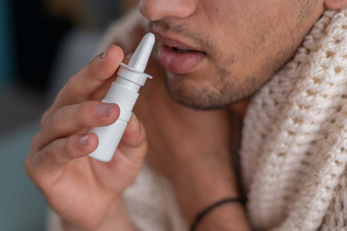 A man demonstrating how to use nasal spray properly