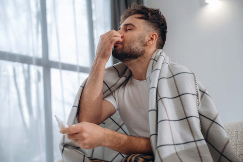 A man using nasal spray and equalizing ear pressure due to clogged ears