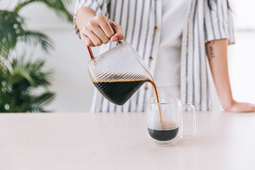a person pouring a cup of coffee