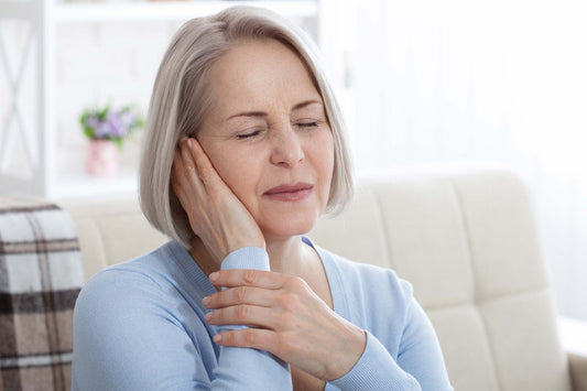 An old woman suffering from clogged ears due to allergies
